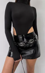 Mini falda negra de efecto charol, con corte recto y tiro medio.