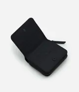 Billetera pequeña de poliuretano color negro, con cierre de cremallera y textura geométrica triangular. Incluye placa metálica con el logo de la marca en el frente.