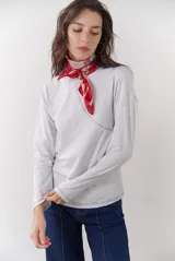 Remera blanca de manga larga con cuello redondo y costuras decorativas en contraste de color negro.