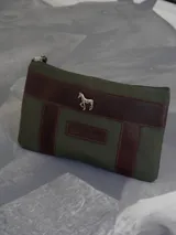 Sobre tipo cartuchera de lona naranja con detalles y apliques en cuero marrón. Presenta un aplique metálico en forma de caballo y un parche con el logo de la marca grabado en el frente.