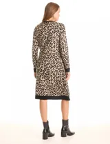 Vestido de tejido de punto marca Nina Leonard, con diseño Twofold que simula un conjunto de vestido negro liso y cárdigan largo con estampado geométrico blanco y negro. Presenta escote redondo y manga larga de corte recto.