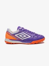 Championes de fútbol 5 Umbro Bump, color violeta con detalles en naranja y blanco. Presentan un diseño texturizado en la puntera y el logo de Umbro en los laterales.