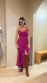 Vestido midi color uva con escote corazón, tirantes finos y aberturas laterales en la cintura. Presenta un diseño con frunces frontales y una falda con tajo lateral.
