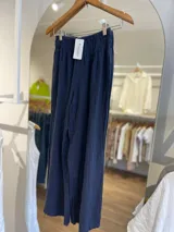 Pantalón ancho de lino blanco, con cintura elástica fruncida y corte cropped.