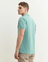 Chomba verde con cuello polo y tapeta de dos botones.