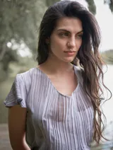 Blusa color naranja de gasa pintada con cuello asimétrico y mangas cortas.