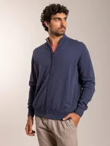 Campera color beige de tejido de punto con cierre frontal y cuello alto.