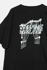Remera boxy negra de algodón, con cuello redondo, manga corta y estampa frontal blanca con texto.