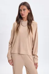 Hoodie de tejido rib color beige, con capucha, manga larga y corte holgado.