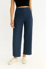 Pantalón de tejido acanalado color marrón oscuro, tiro alto y corte ancho (wide leg) a la altura del tobillo.