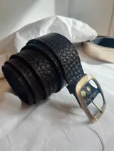 Cinto de cuero con hebilla metálica dorada.