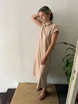 Vestido midi negro de algodón, con mangas cortas, cuello redondo y bolsillos laterales.