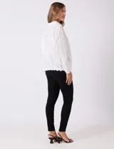 Camisa de algodón blanca con bordados florales verticales, cuello con solapa y cierre frontal con botones.