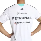 Remera deportiva Adidas del equipo Mercedes AMG Petronas, color blanco con detalles en negro y turquesa. Incorpora múltiples logotipos de patrocinadores impresos en el frente y las mangas, cuello en V y las clásicas tres tiras de Adidas en los hombros.