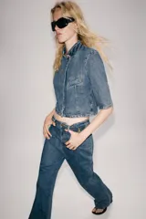 Jeans flare de tiro alto de Zara Woman Collection, en color azul con efecto lavado. Presentan un corte slim en la parte superior y perneras acampanadas con raya planchada al frente y dobladillo ancho. Incluyen cierre frontal con cremallera y botón.