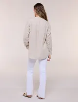 Blusa de lino de la marca Dash, color beige, con cuello mao y escote en V con botones frontales. Cuenta con bolsillos plaqué con solapa en el pecho y mangas largas con sistema para arremangar.