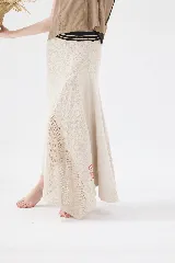 Falda larga de punto color mostaza, con cortes asimétricos, distintos puntos texturizados, ruedo irregular y pretina elástica con detalles en tono contrastante.