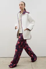 Pantalón de tiro alto y corte recto, confeccionado en tela brocato con estampado floral y de aves en tonos azul marino y rosado.