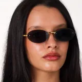 Lentes de sol con diseño ovalado y montura metálica dorada. Cuentan con cristales oscuros y protección UV400.