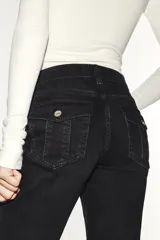 Jeans de tiro bajo y diseño bootcut, con efecto lavado, trabillas y cinco bolsillos clásicos. Cuenta con cierre frontal de cremallera y botón metálico.