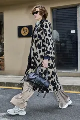 Tapado largo de poliéster con estampado animal print tipo leopardo, solapas amplias y cierre frontal cruzado con botones.