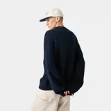 Sweater de punto grueso color azul marino, con cuello redondo, corte cuadrado y ligeramente corto. Presenta gráficos de "EME STUDIOS curated by bien ice" en jacquard blanco en el frente. Tiene puños ajustados.