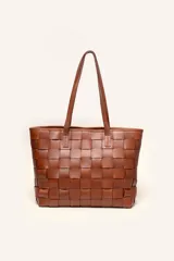 Cartera tipo tote de cuero marrón, confeccionada con diseño trenzado artesanal y doble asa de hombro.