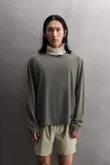 Camiseta de entrenamiento regular fit color gris oscuro, confeccionada en tejido técnico ligero y elástico con estructura. Cuenta con cuello redondo, manga larga y logo estampado en el bajo.