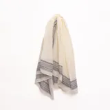 Pashmina beige con detalles estampados geométricos y paisley en los bordes en tonos oscuros.