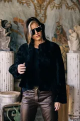 Saco corto negro de piel de cordero, con bolsillos laterales y corte holgado.