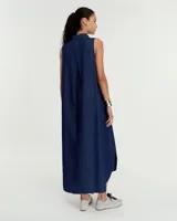 Vestido evasé sin mangas confeccionado en denim liviano, con cuello mao y falsa cartera que forma un escote en V. Presenta bolsillos laterales, un tablón en el centro de la espalda y ruedo redondeado con tajos laterales. El largo es hasta la mitad de la pantorrilla.