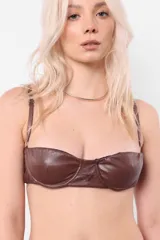Top brasier color marrón de cuerina elastizada, con aro media copa en busto, breteles regulables y acceso por espalda mediante lazo.