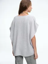 Chaleco tejido de punto en color gris, con escote en V y diseño de silueta amplia y relajada.