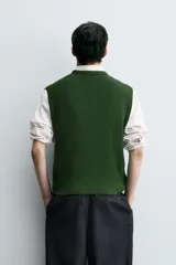 Chaleco de punto color verde oscuro, corte relajado (relaxed fit), con cuello redondo y sisas terminadas en rib.