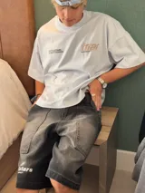 Remera color crema de corte holgado con mangas cortas y estampado en la espalda con el logo de la marca Ittai en color marrón.