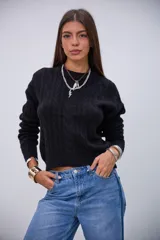 Sweater negro de punto con diseño de ochos, cuello redondo y mangas largas.