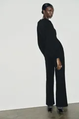 Pantalón de tiro alto con corte ancho y recto, confeccionado en tejido de punto elástico y flexible con cintura elástica.