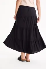 Pollera larga de viscosa color negro, con diseño escalonado de volados y cintura elástica.
