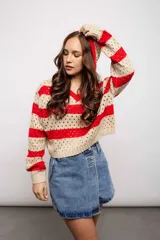 Buzo de tejido de punto calado color beige con rayas horizontales rojas y capucha.