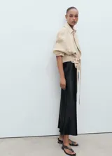 Falda midi evasé de tejido satinado color negro, con tiro medio y cintura elástica sin cierre.