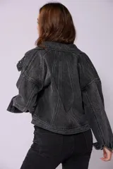 Campera de jean de lavado celeste claro, con diseño clásico de cuello y botones metálicos. Presenta detalles de pequeños brillos o tachas plateadas sobre la tela, especialmente visibles en los bordes de los bolsillos y costuras.