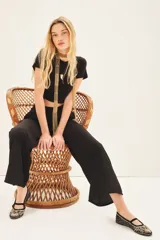 Pantalon de vestir color negro, de corte amplio y fluido con pierna ancha, tiro alto y cintura elástica.