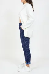 Pantalón de corte ajustado confeccionado en tejido jacquard con estampado sutil en tonos azules. Presenta bolsillos delanteros funcionales, cierre frontal y un diseño que estiliza la figura.