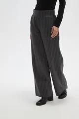 Pantalon de vestir de corte recto y tiro alto, confeccionado en tela de viscosa con diseño de rayas verticales finas en color blanco sobre fondo negro.