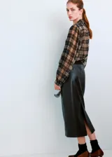 Blusa de manga larga con estampado de cuadros en tonos marrones y grises, cuello clásico y cierre frontal con botones ocultos.