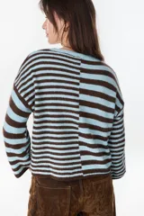 Sweater de punto a rayas horizontales en color chocolate y crudo, con cuello redondo y diseño holgado.