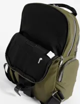 Mochila de cuero vegano color verde oliva, con compartimento principal, bolsillo frontal con cierre y bolsillos laterales. Cuenta con correas superiores de mano y herrajes metálicos plateados.