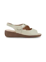 Sandalias de cuero color crema, con tira ajustable con velcro en el empeine, talón cerrado con tira elástica y suela de plataforma baja marrón.