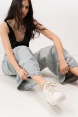 Championes de cuero color blanco con detalle de corona en animal print y talón verde. Cuentan con suela de caucho, lengüeta de gamuza y forro textil, con cierre mediante cordones al tono.