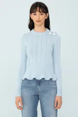 Sweater celeste de tejido de punto con calce al cuerpo, cuello redondo, mangas largas, volado en el ruedo y botones decorativos en el hombro.